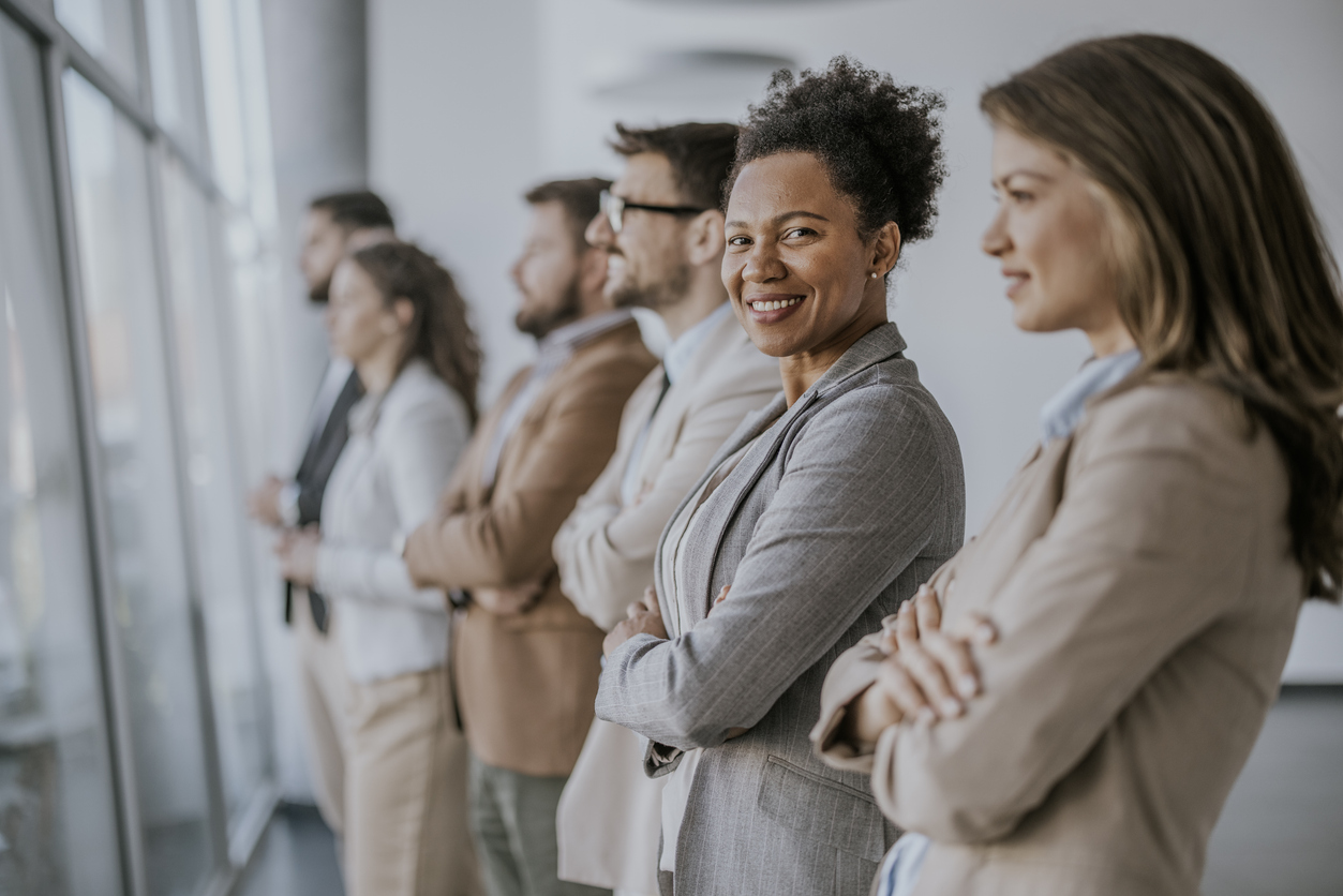 Confident business professionals standing in a row in an office setting